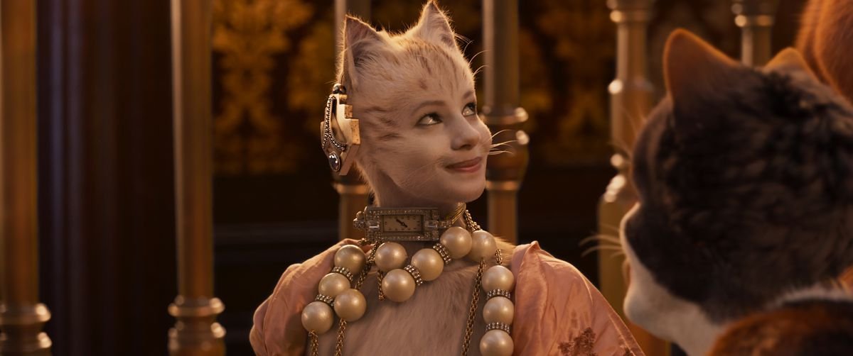 Victoria (Francesca Hayward), a white cat, wearing a string of pearls in Cats