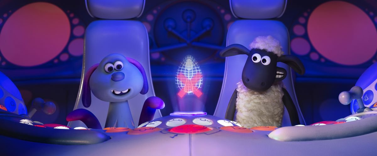 An alien and a sheep sit inside a spaceship.