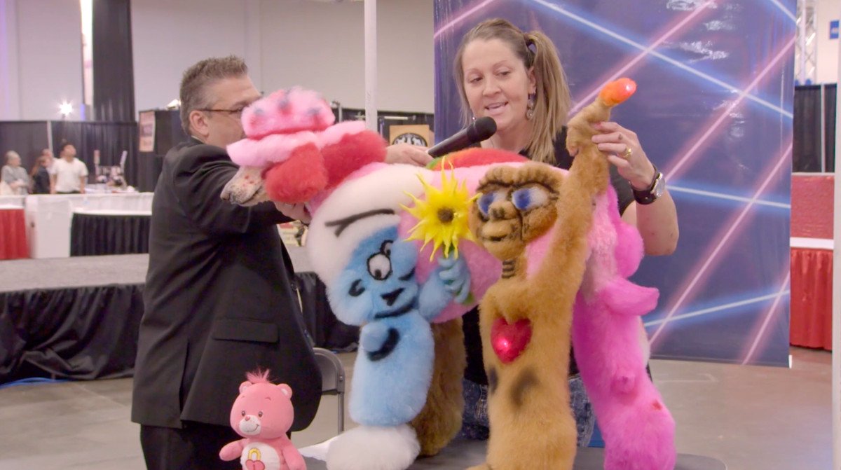 A groomer shows off her poodle, which has a smurf and E.T. dyed into its side, at a competition in Well Groomed