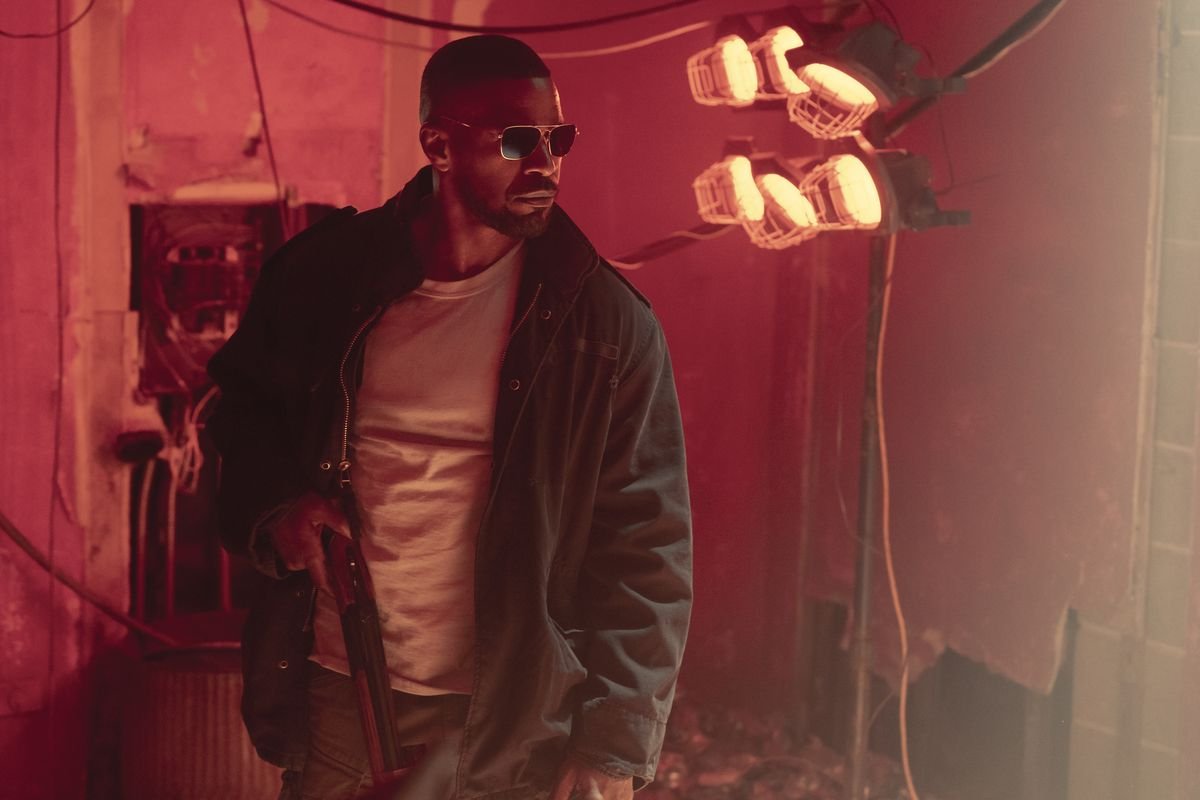 Jamie Foxx wearing sunglasses and carrying a shotgun in Project Power