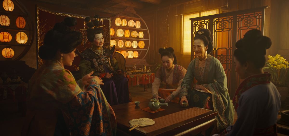 a group of women sit around a table in mulan