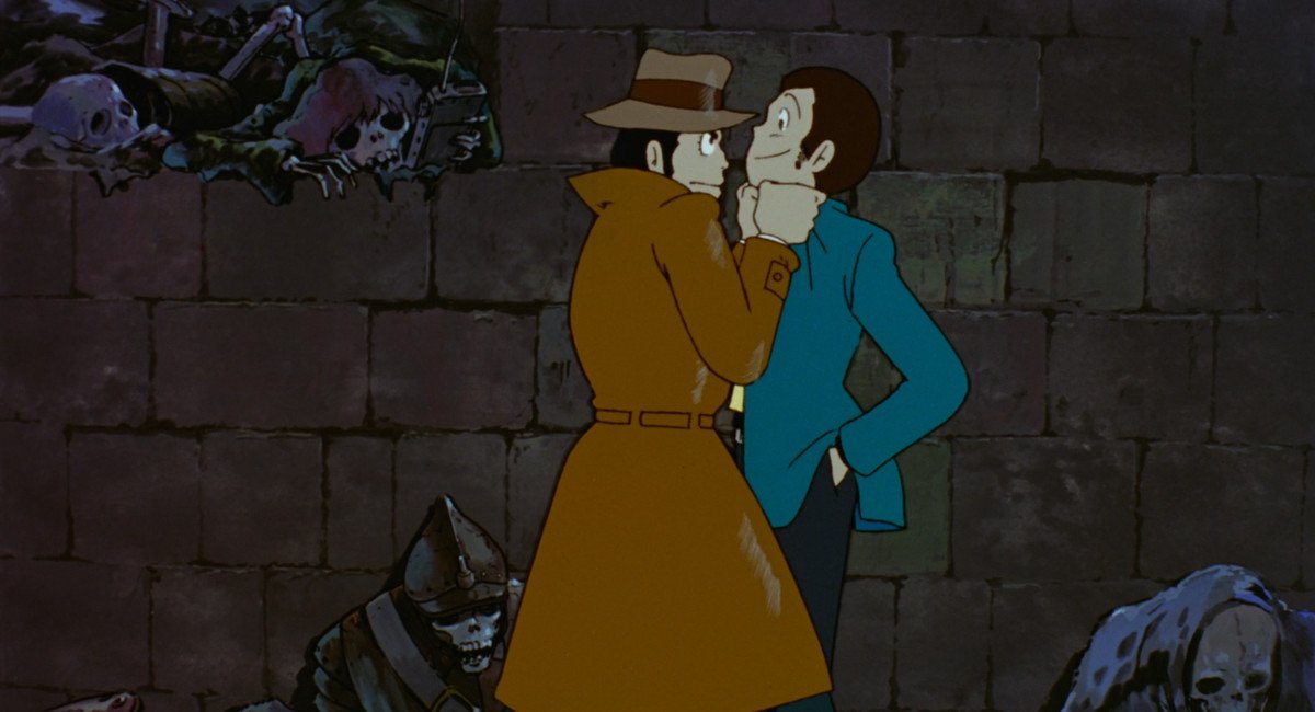 Interpol Inspector Zenigata holds master thief Lupin III by the lapels in a skeleton-filled crypt in The Castle of Cagliostro