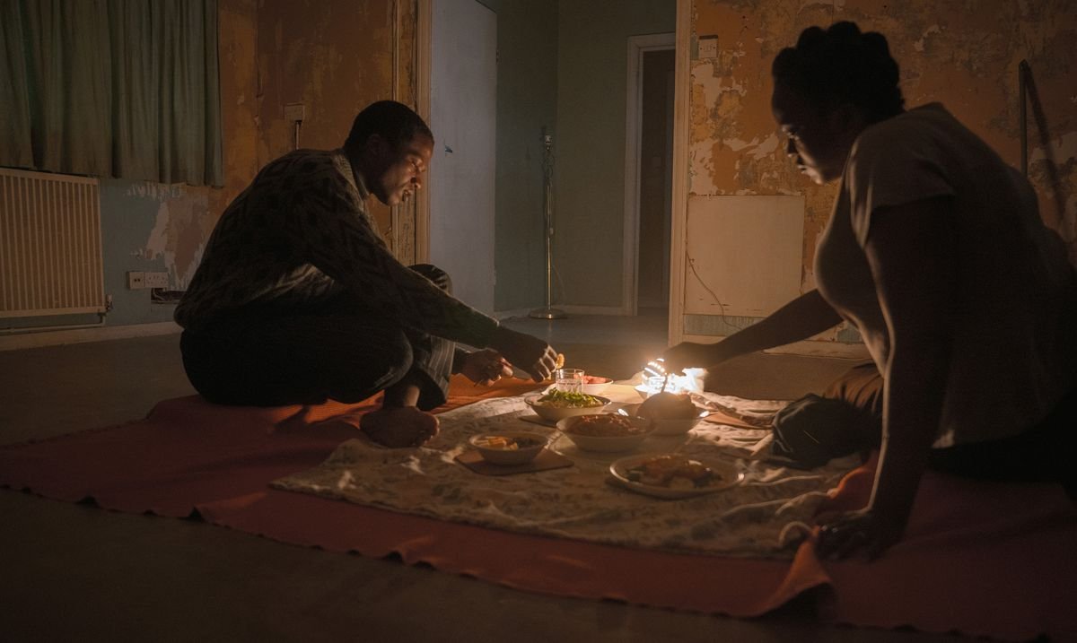 Sudanese refugees Bol (Sope Dirisu) and Rial (Wunmi Mosaku) have dinner on the floor of their unfurnished (and very haunted) row house in His House.