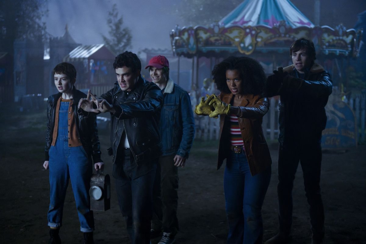 Sabrina’s friends gather at a carnival at night, in front of a carousel, in Chilling Adventures of Sabrina