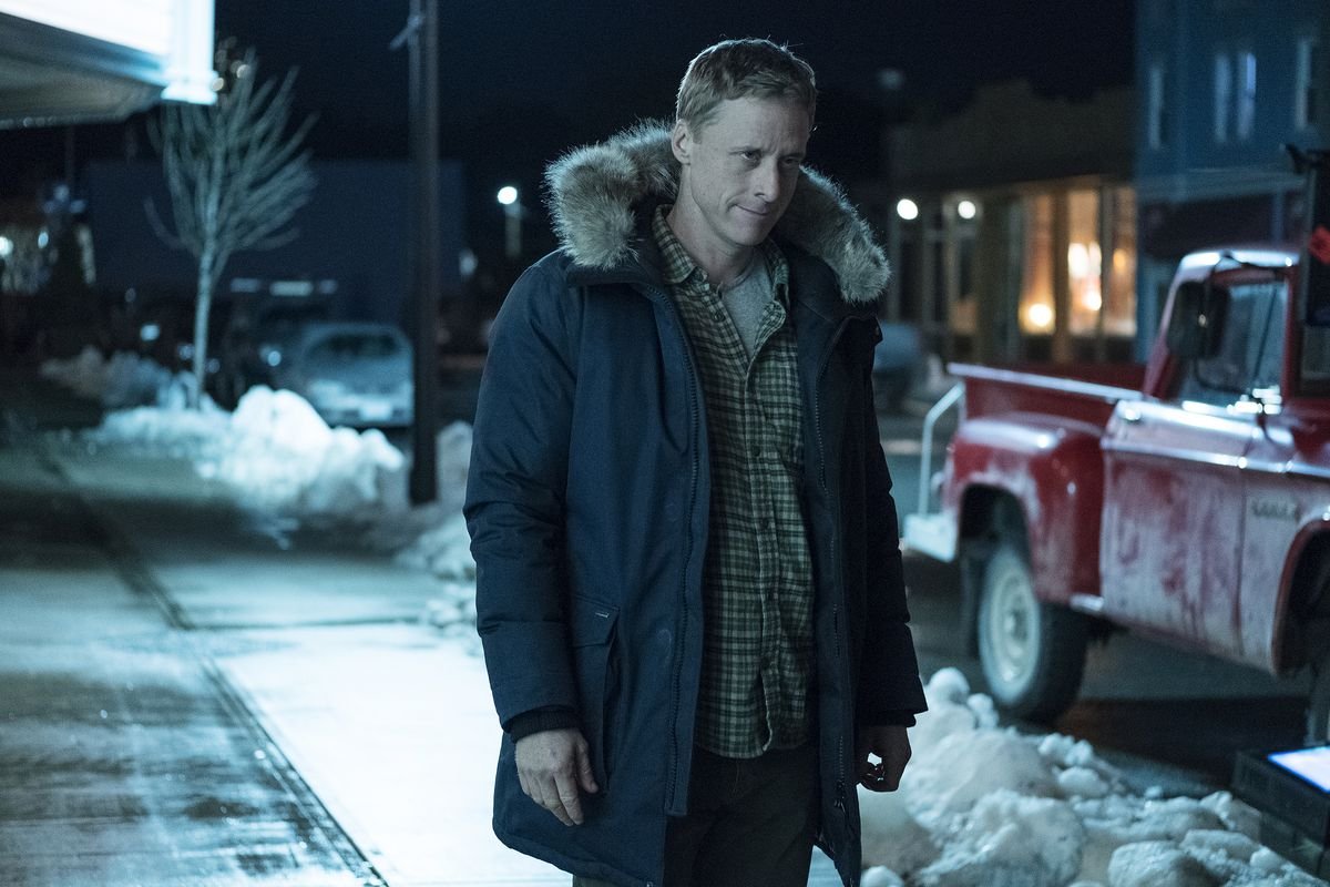 Alan Tudyk at night on the street, looking inhuman in Resident Alien