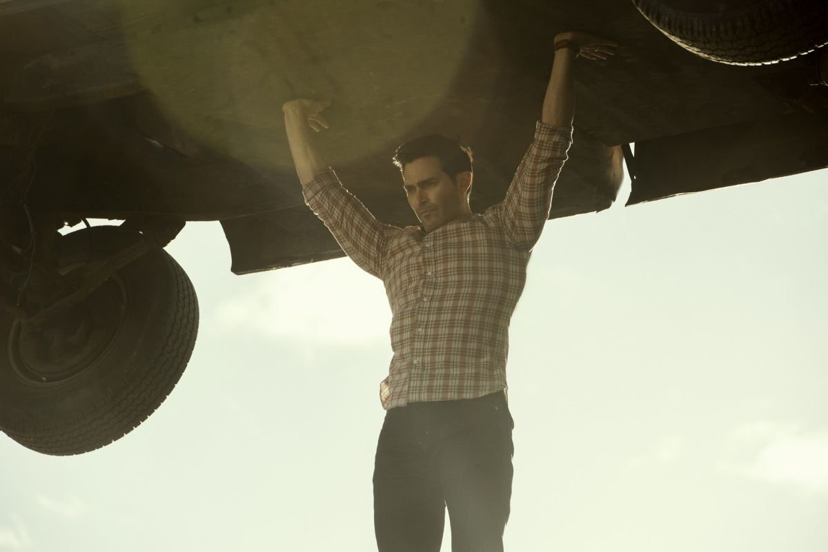 Tyler Hoechlin as Clark Kent holds a truck up over his head in Superman & Lois