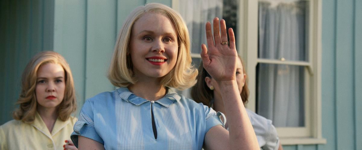 Alison Pill waves with a stiff smile in Amazon Studios’ Them