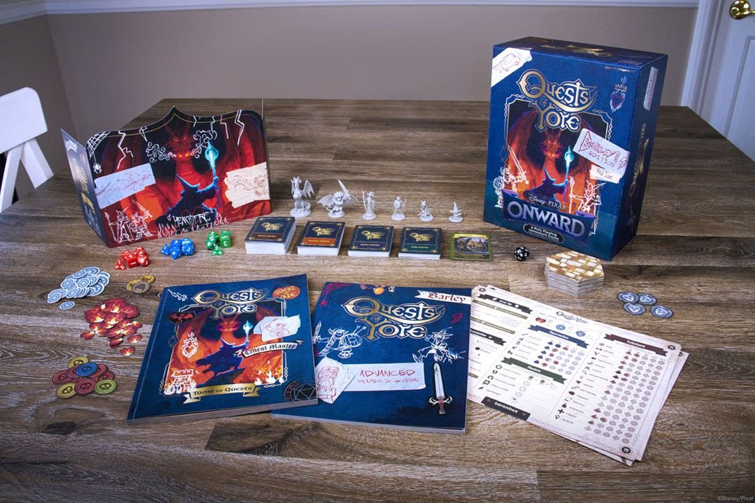 The components inside Quests of Yore all laid out for display. The game master’s screen shows a wizard squaring off against a dragon, with doodles and faux masking tape holding it together.