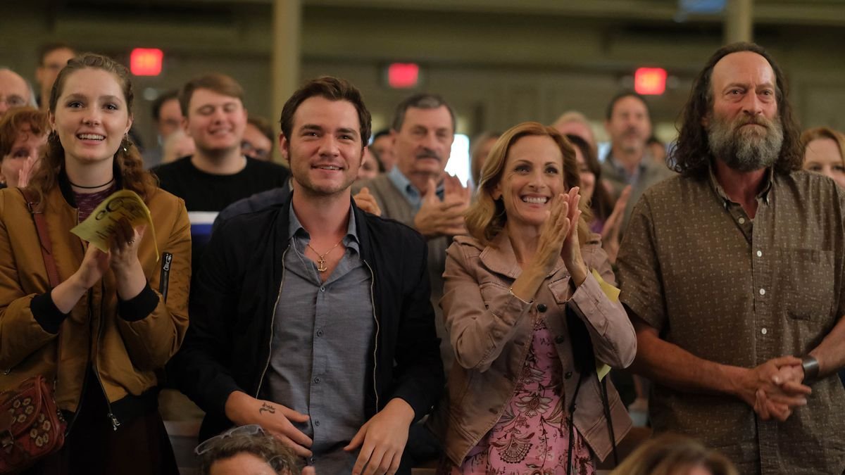 Troy Kotsur, Daniel Durant, and Marlee Matlin applauding in an auditorium in CODA