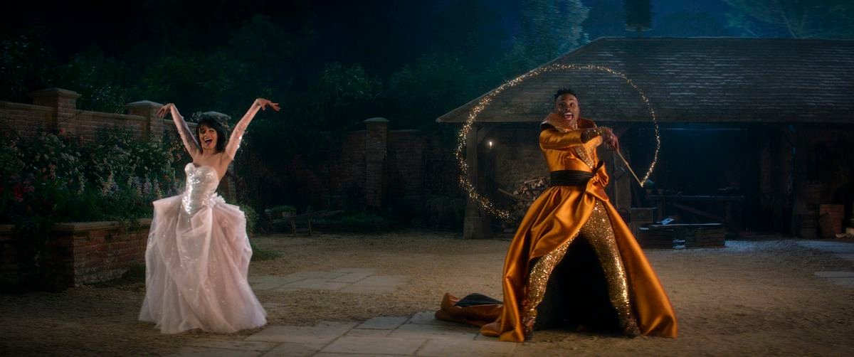 A ballgowned Cinderella (Camila Cabello) and her Fabulous Godmother (Billy Porter) dance outside in Amazon’s Cinderella