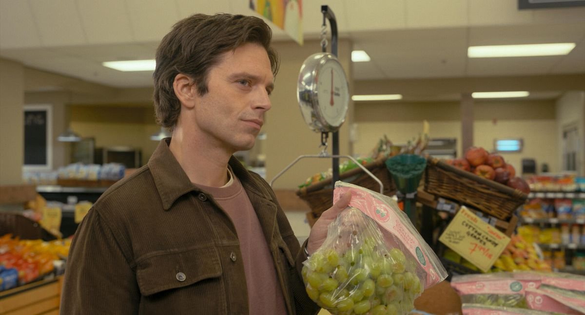 Sebastian Stan suggestively holds up a bag of bruised grapes in the grocery store, which was probably not a thing you realized someone could do