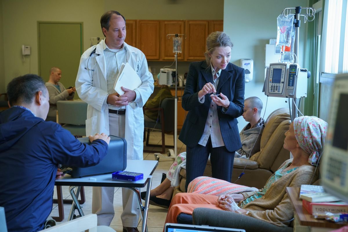 Elizabeth Holmes explaining a trial to a patient in a still from The Dropout