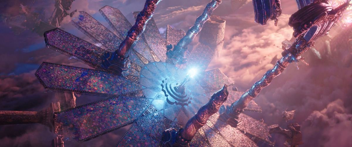 A pink-and-purple CGI vista seen through a Dutch tilt, showing a glowing blue-white light on a plinth surrounded by narrow, twisted minarets in Doctor Strange in the Multiverse of Madness.