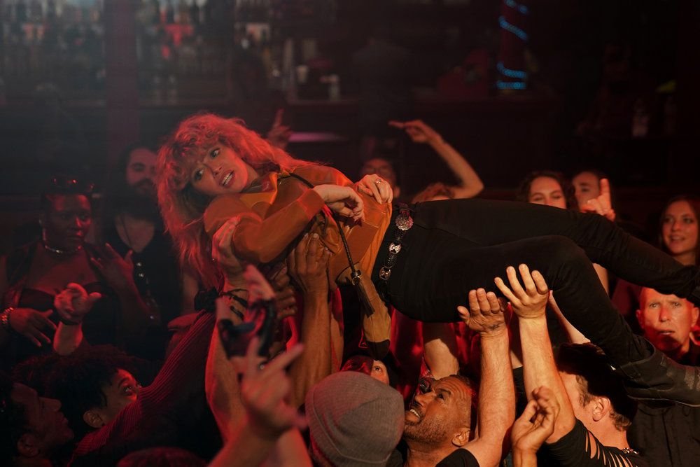 Charlie (Natasha Lyonne) gets carried by a raving crowd of metalheads in Poker Face