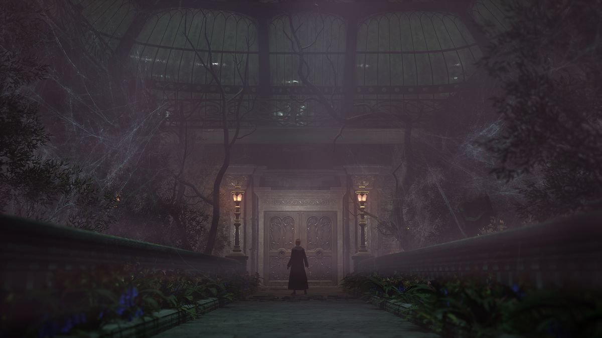 A witch stands in front of a door in Hogwarts Legacy in a dimly lit greenhouse