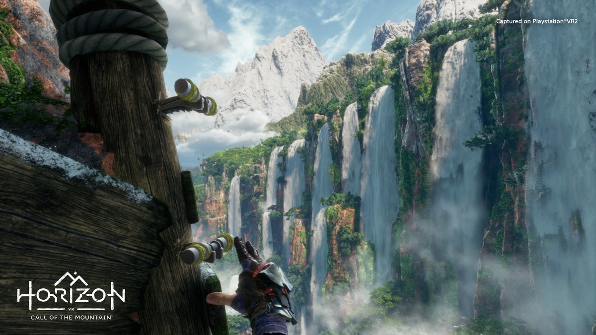 Climbing a cliffside and glancing to the right at a series of massive waterfalls in VR in Horizon Call of the Mountain