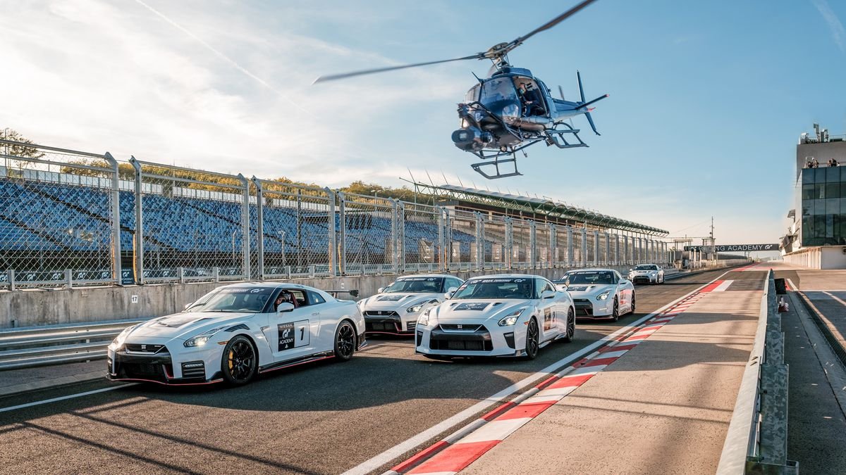 A helicopter buzzes a row of white Nissan racing cars in the Gran Turismo movie