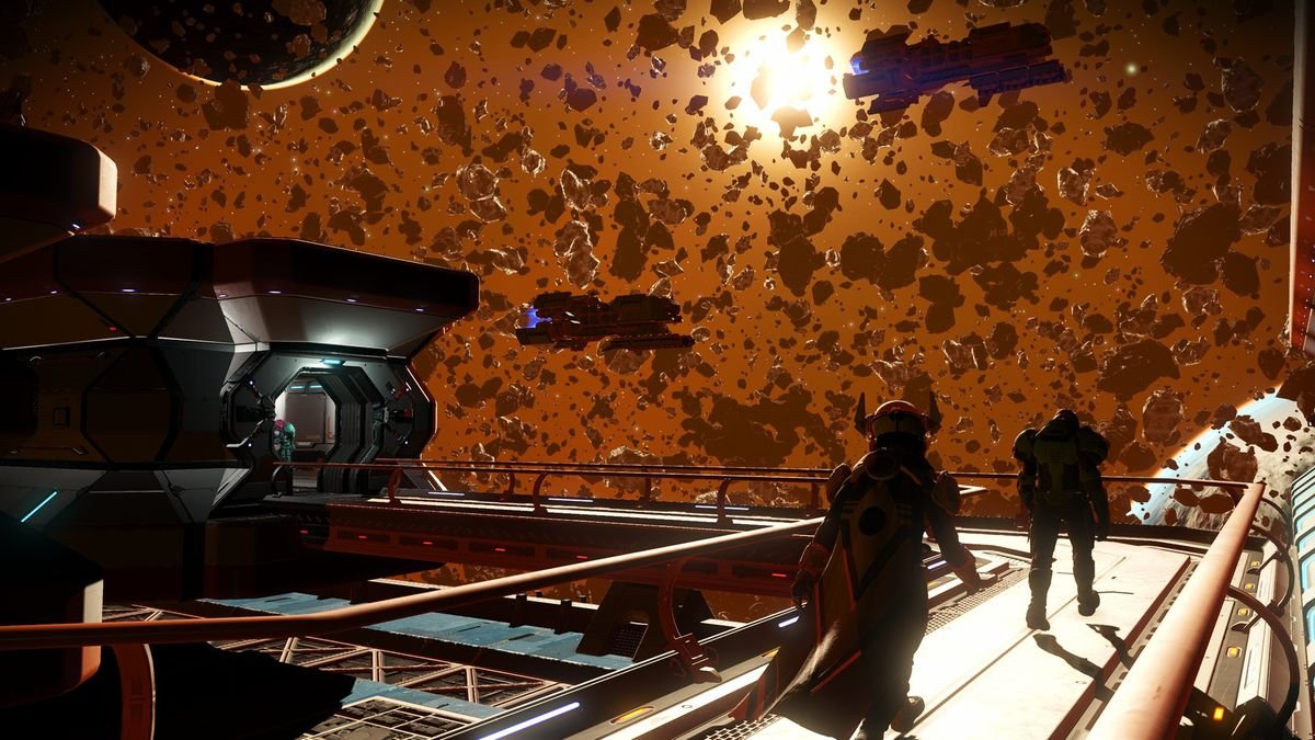 Two explorers walk along the exterior catwalk of a space station in the midst of a meteor cluster in No Man’s Sky