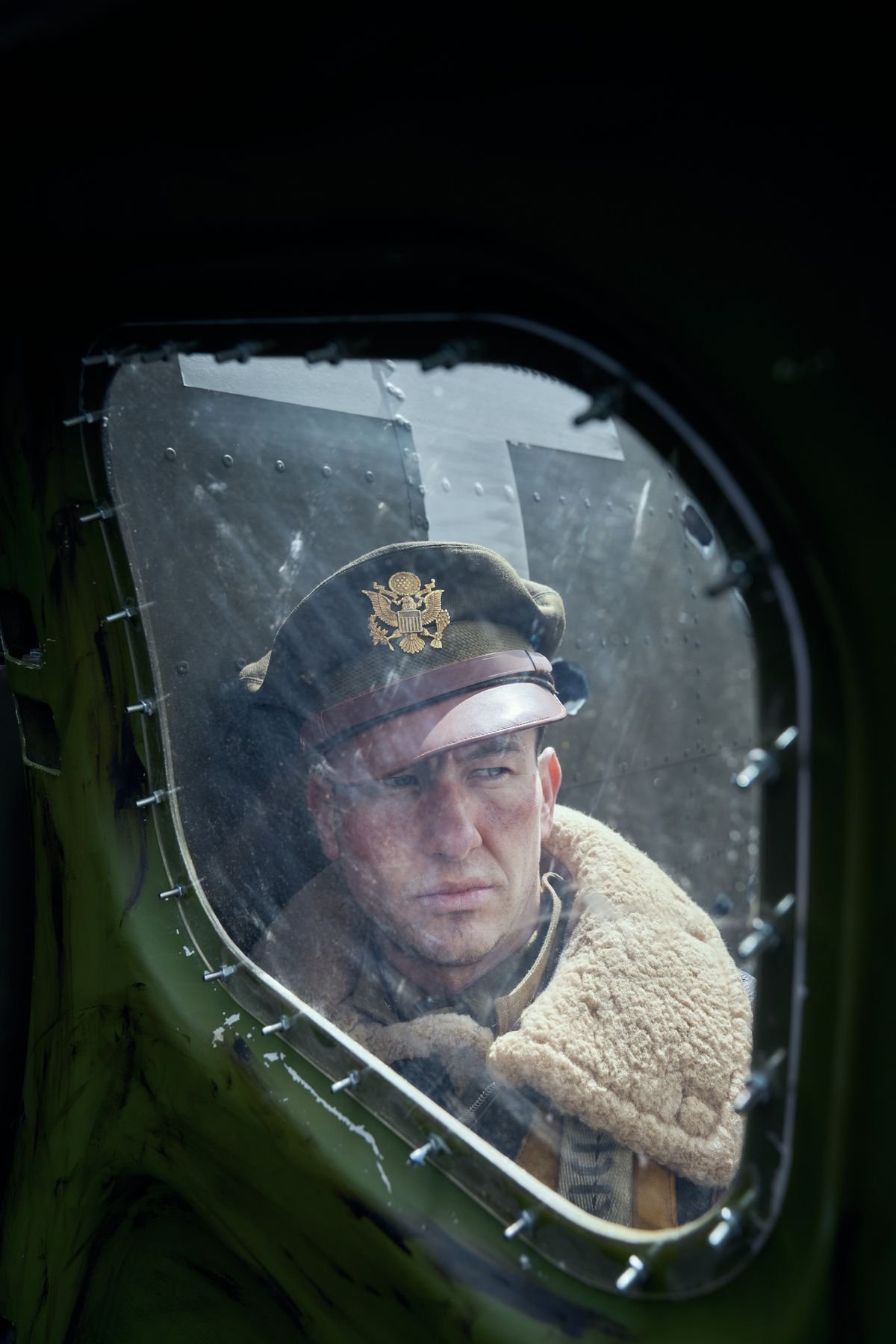 Barry Keoghan cats a skeptical eye through the window of his Fort in an early scene from Masters of the Air.