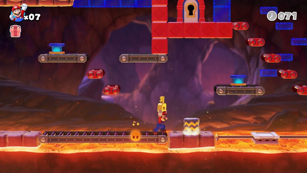 Mario carries a large key toward a locked door in a lava level
