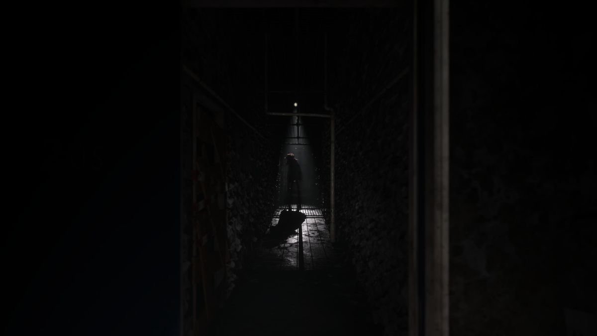A monster down a long nearly dark hallway in Silent Hill: The Short Message. It’s only illuminated by a small overhead light.