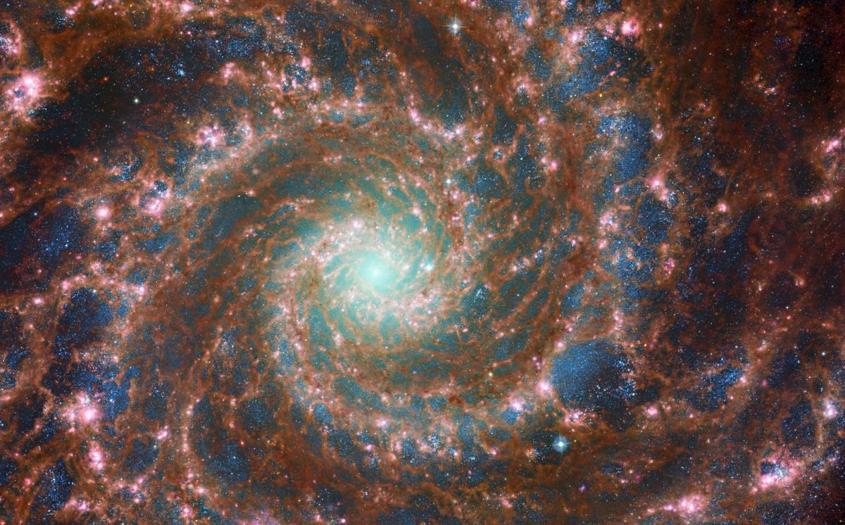 M74 galaxy in a combined optical and infrared image, showcasing the spiral of the galaxy, as shot by the James Webb Space Telescope