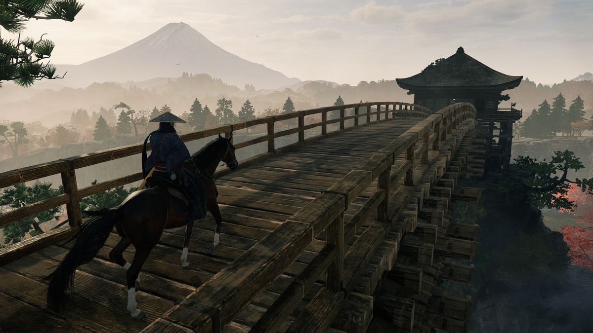 A player riding a horse across a wooden bridge with Mt. Fuji visible in the distance.