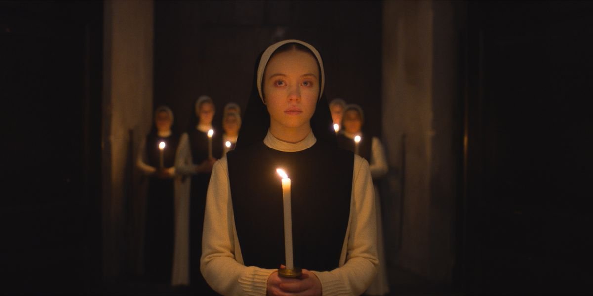 Sydney Sweeney in Immaculate holding a candle with nuns behind her 