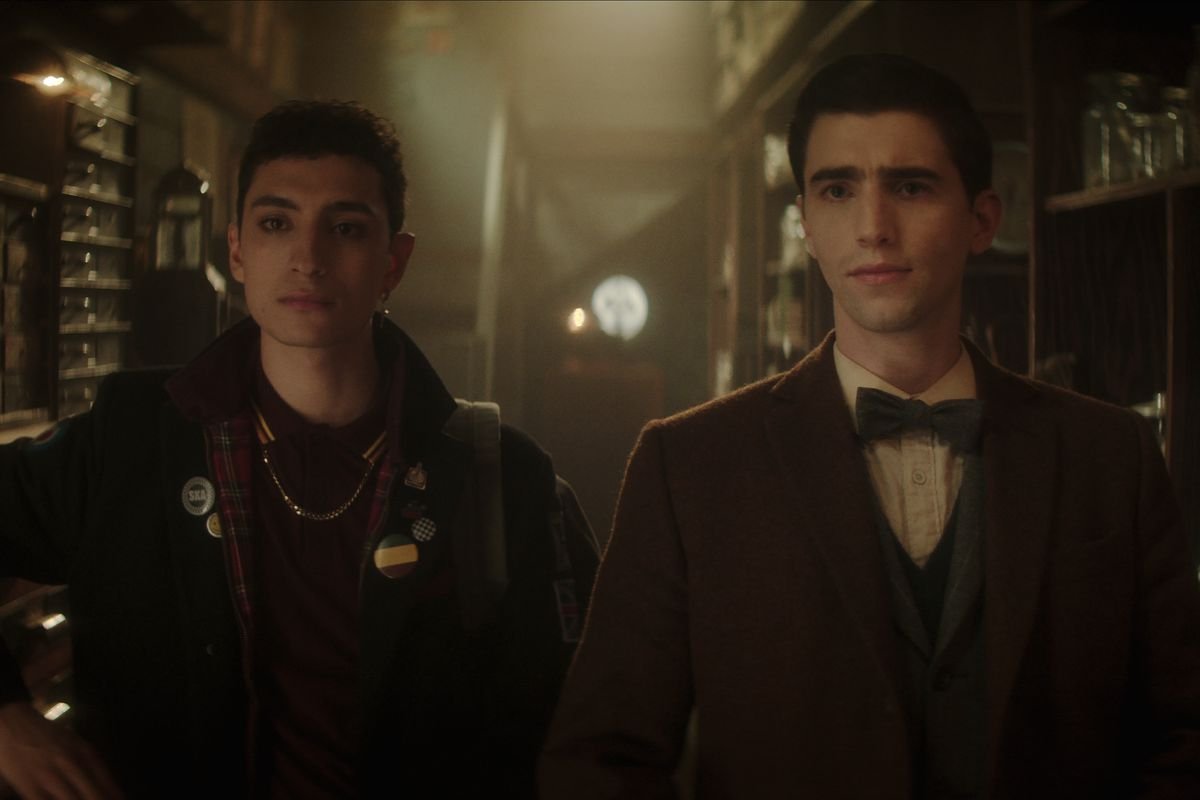 Charles and Edwin stand side-by-side in a supernatural shop