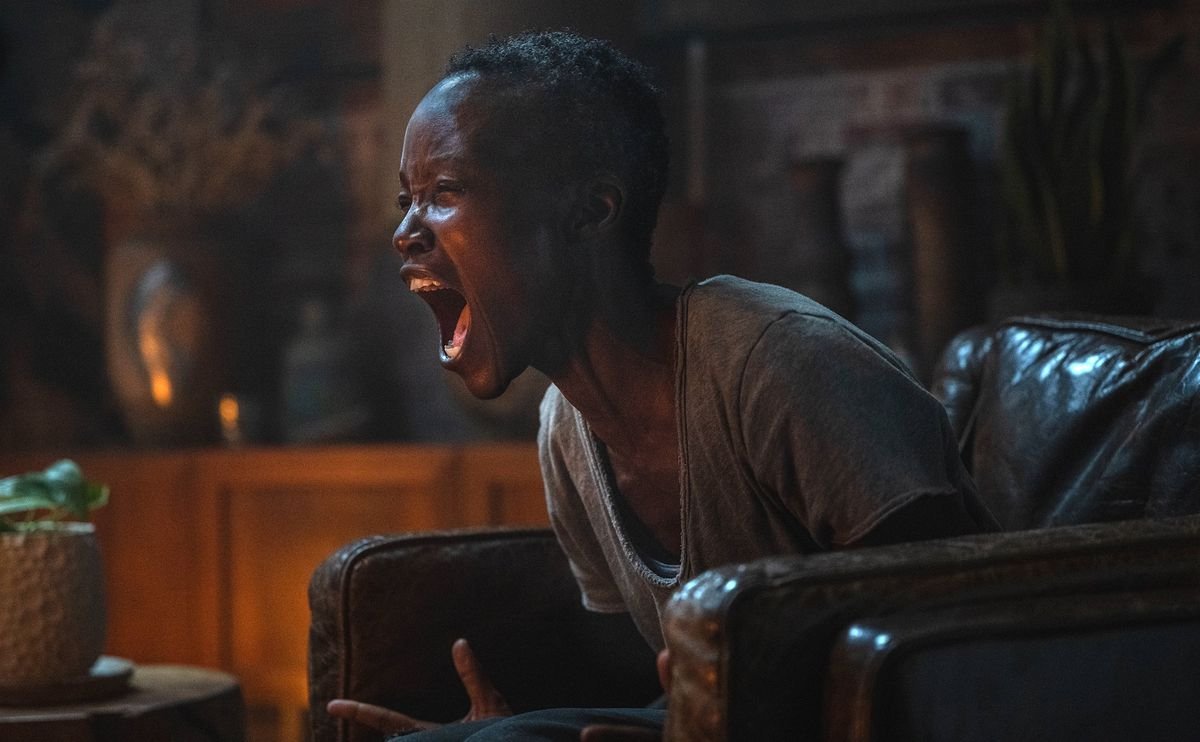 Sam (Lupita Nyong’o), sitting in a big leather easy chair in a dim room, closes her eyes and screams in Michael Sarnoski’s A Quiet Place: Day One