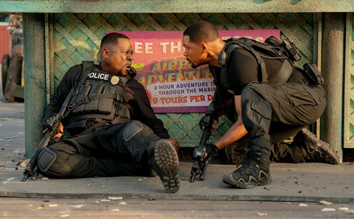 Detective Marcus Burnett lies in SWAT gear against cover as an equally kitted-out Mike Lowrey gives him a pep talk in Bad Boys: Ride or Die