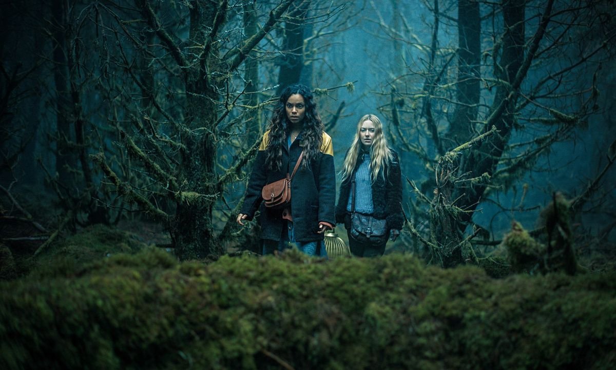 Mina (Dakota Fanning) and Ciara (Georgina Campbell) walk through a dark forest in Ishana Night Shyamalan’s The Watchers