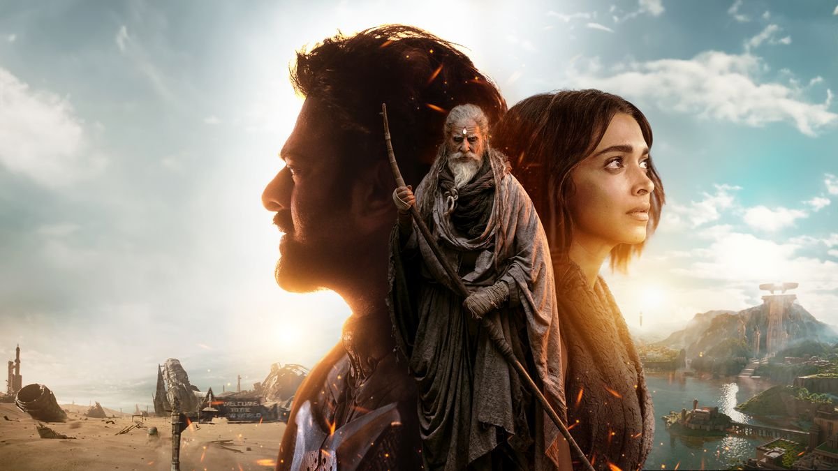 A promo image for the Indian sci-fi blockbuster Kalki 2989 AD composites a young man and woman facing away from each other, with an older, white-bearded man in robes and holding a staff superimposed over both of them. In the background behind the man is a desert wasteland full of shattered, rusty wreckage. In the background behind the woman is a verdant mountain and lake, dotted with buildings.